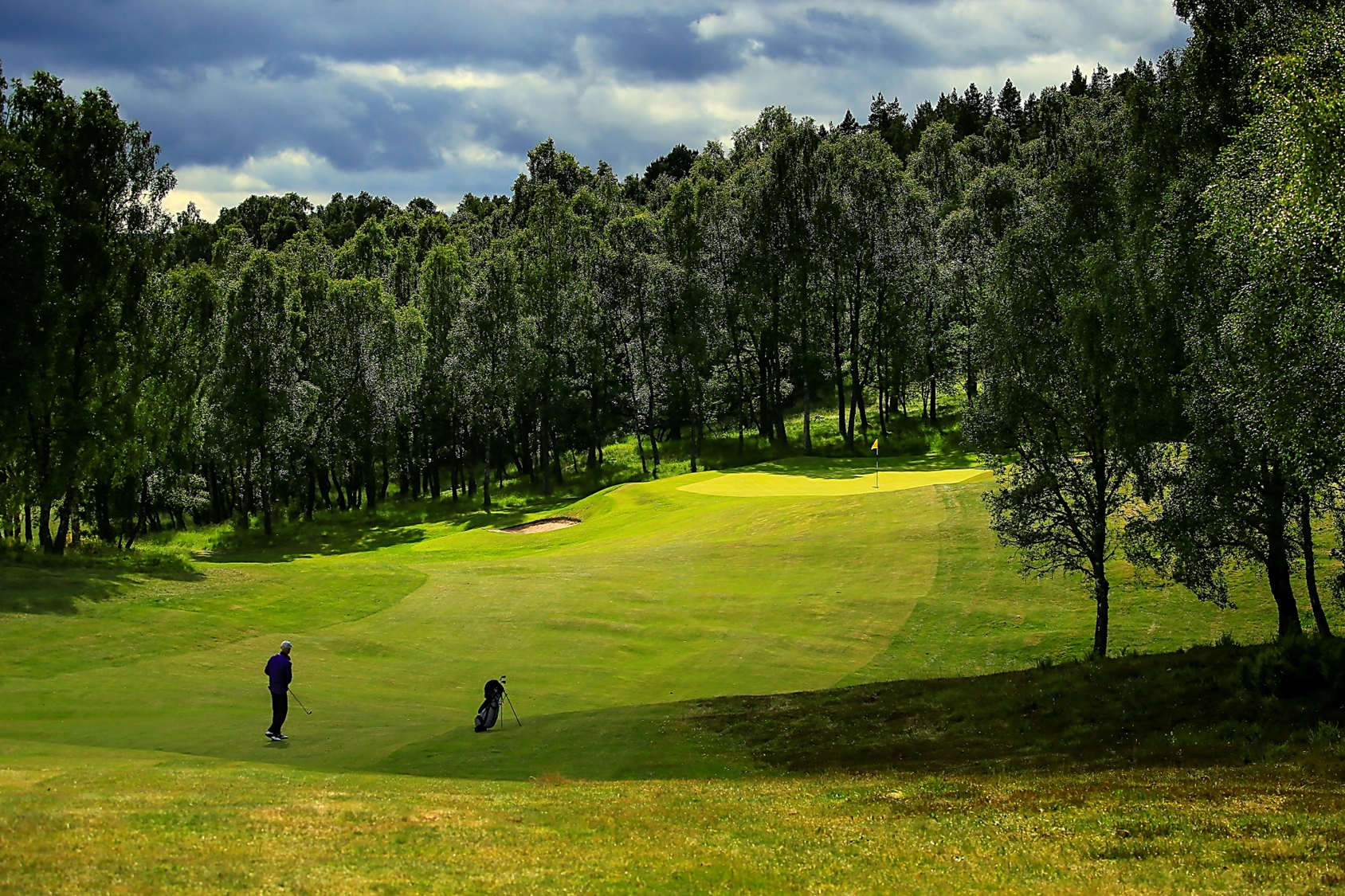 Boat of Garten, golfer playing towards green surrounded by trees