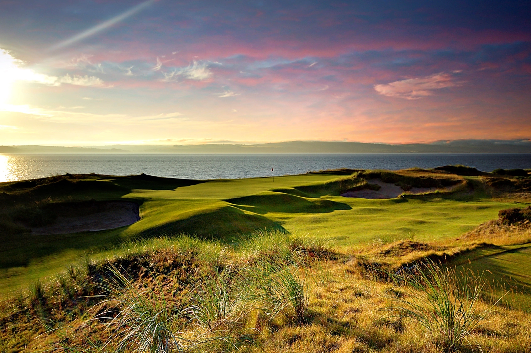 Castle Stuart golf course 11th hole on the waters edge with sunset