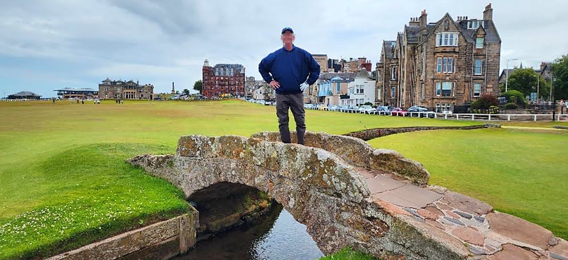 Solo golfer standing on the Swilcan Bridge at St Andrews