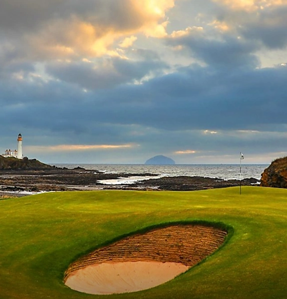 Turnberry 10th green with stormy sky Ailsa Craig on the horizon and lighthouse to the left