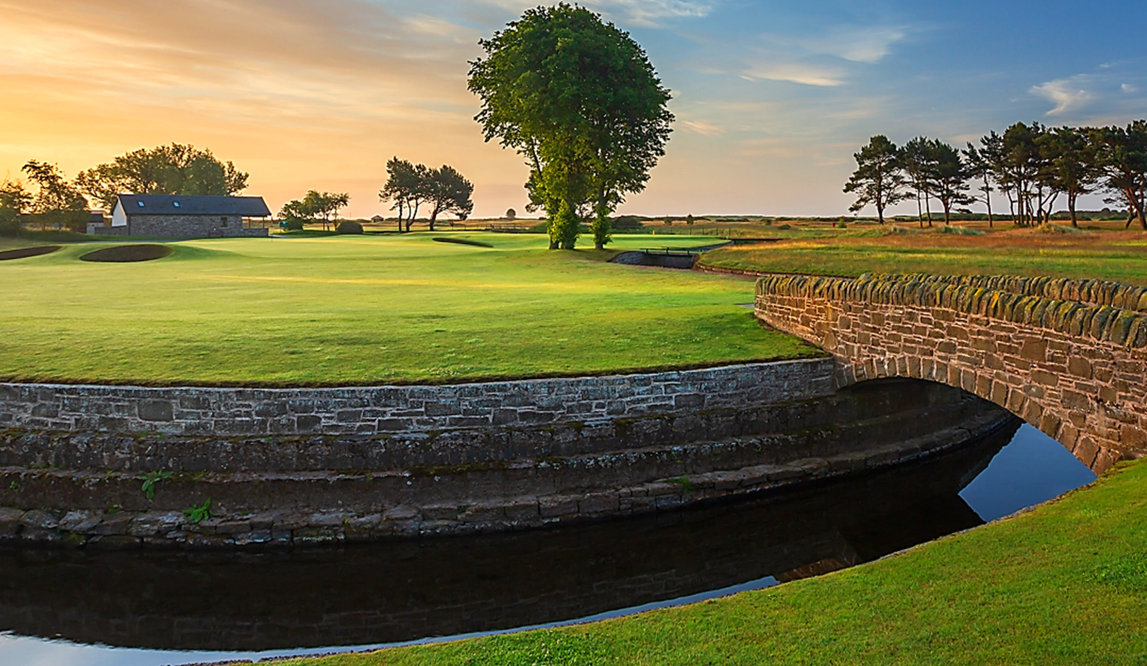 10th green at Carnoustie with Barry Burn winding around the front and prominent tree behind