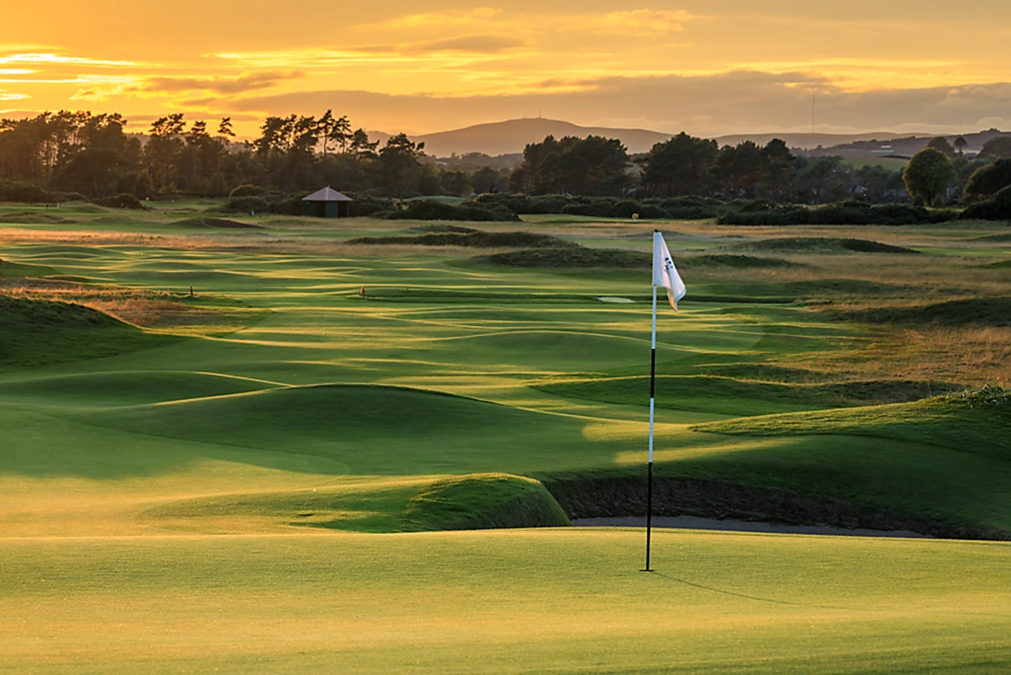 5th green at Carnoustie with rippling fairways in the background