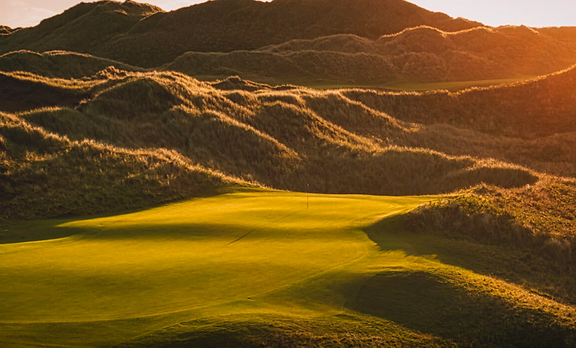Portstewart in fading sunlight with high dunes behind