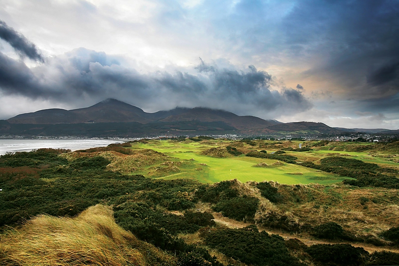 Panorama of Royal County Down with threatening clouds over the moutain