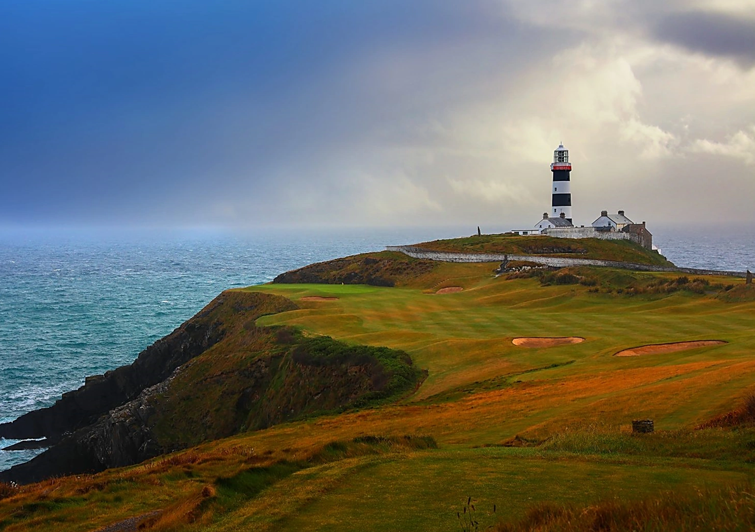 Old Head with lighthouse i=on the tip of the peninsula and sea in the background