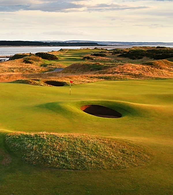 The 11th hole with tee in the background on the St Andrews Old Course with the Eden estuary to the left