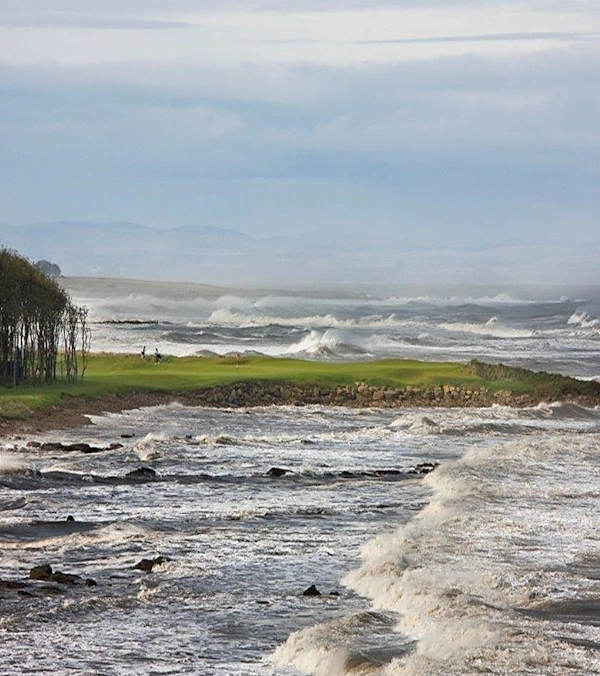 15th green at Kingsbarns in a winter storm with rough sea