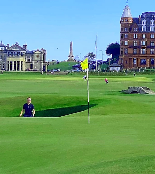 Golfer emerging from the road hole bunker looking towards the green